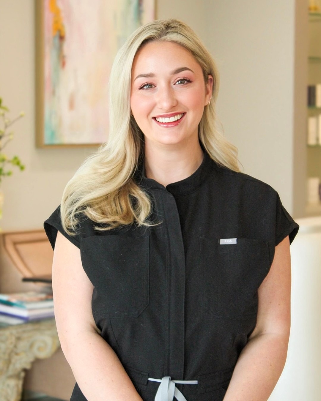Smiling woman in a black outfit indoors.