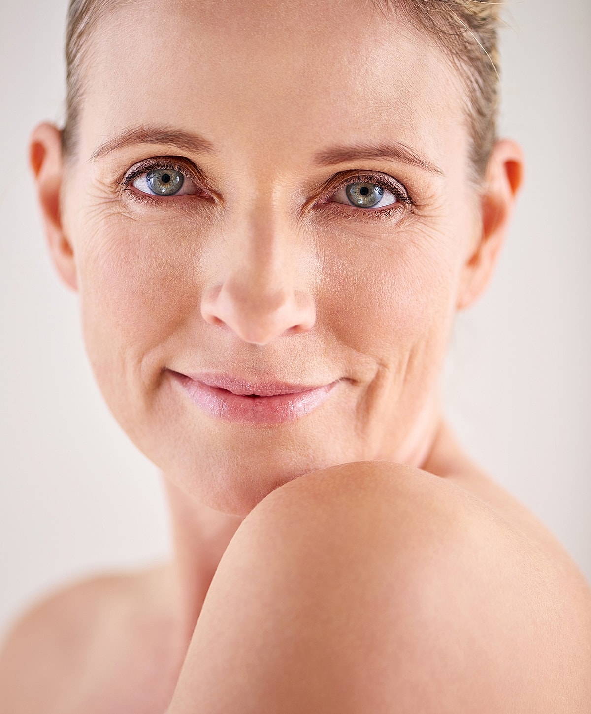 Smiling woman with smooth skin and natural makeup.