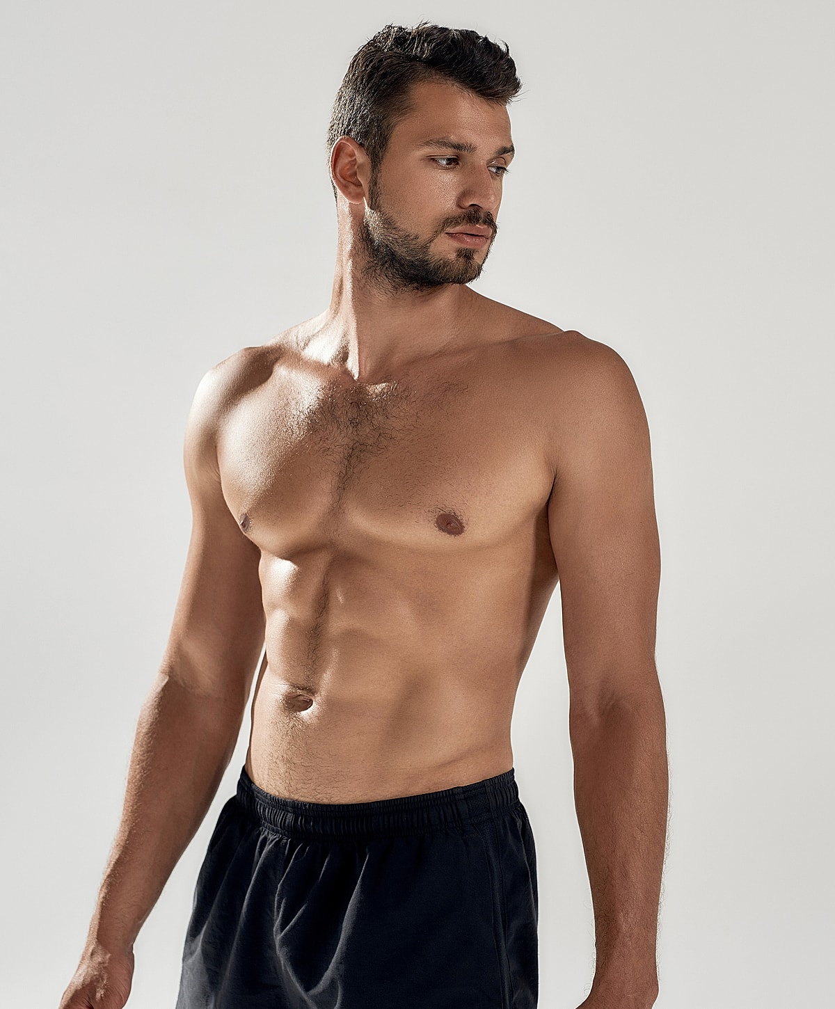 Bare-chested man looking to the side.