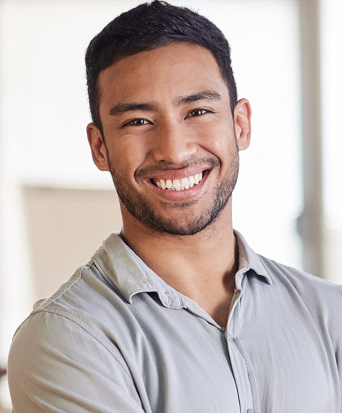 Smiling man in casual attire, indoor setting.
