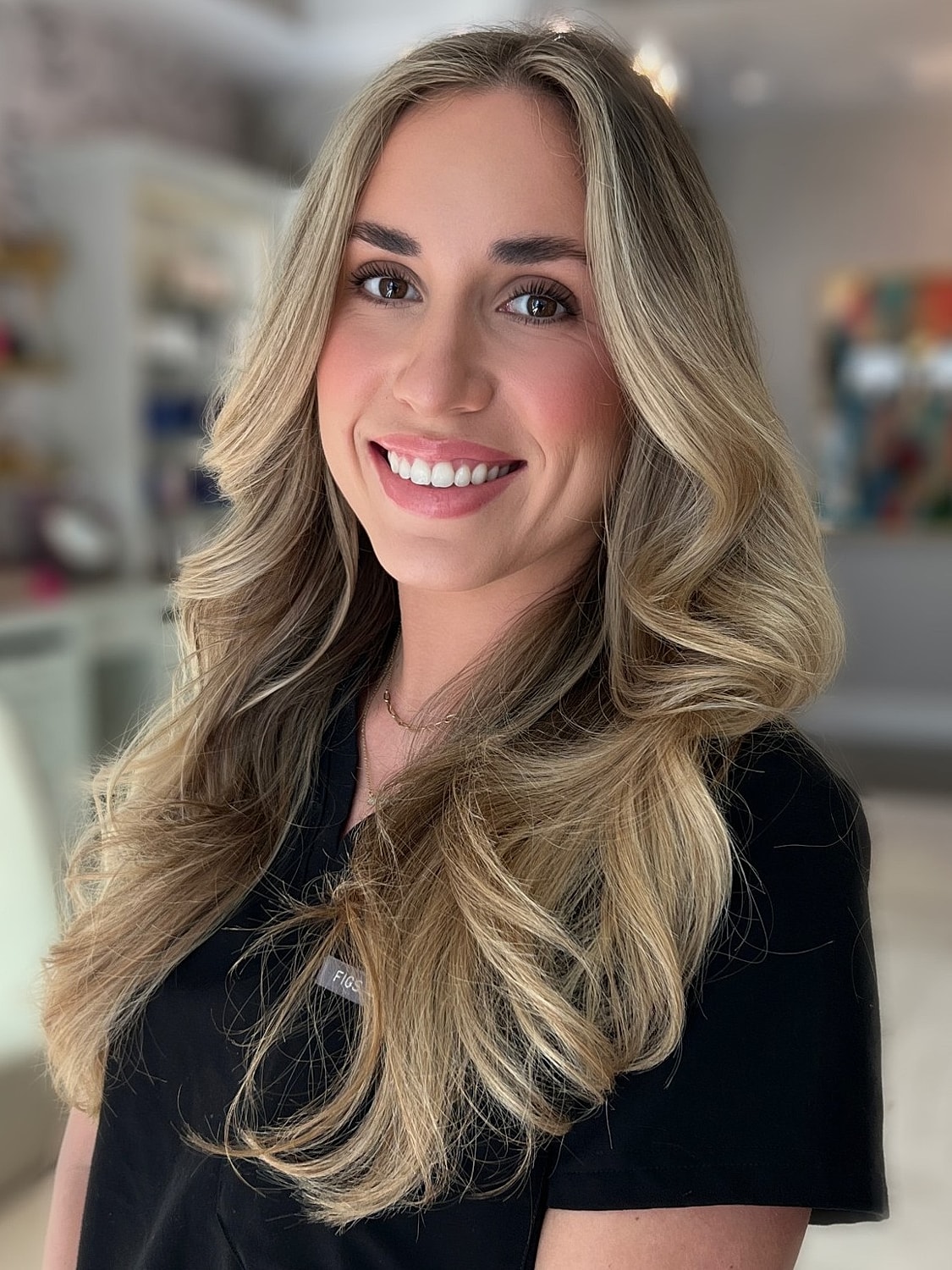 Smiling woman with long, blonde hair indoors.