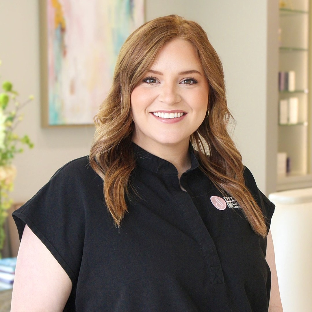 Smiling woman in professional attire indoors.