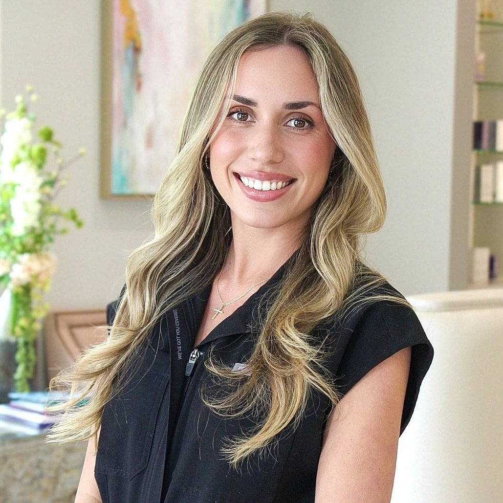 Smiling woman in professional attire, interior background.