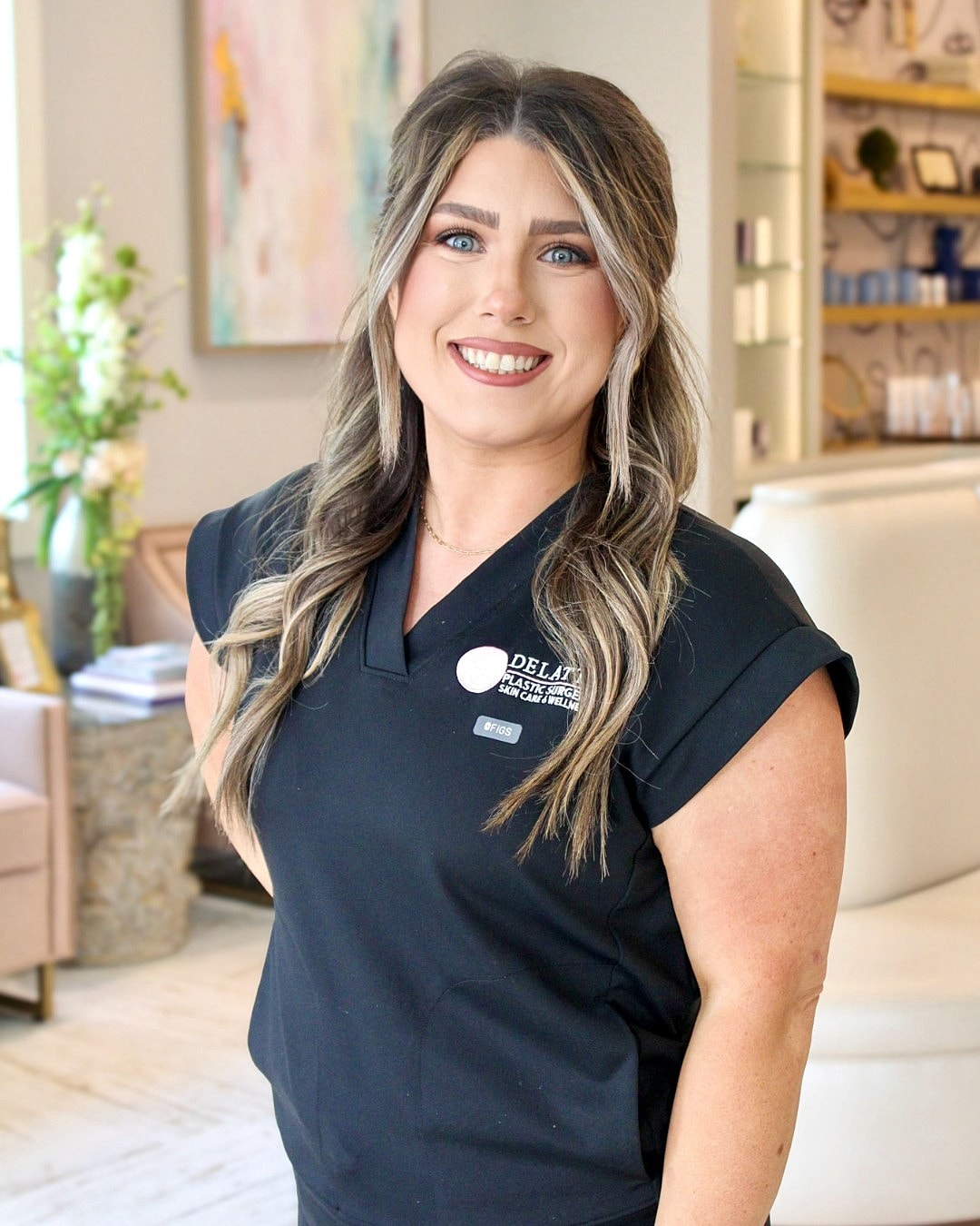 Smiling professional in clinic setting, wearing black.