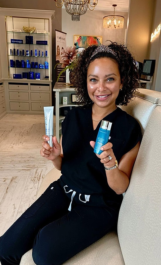 Woman holding skincare products in a spa setting.