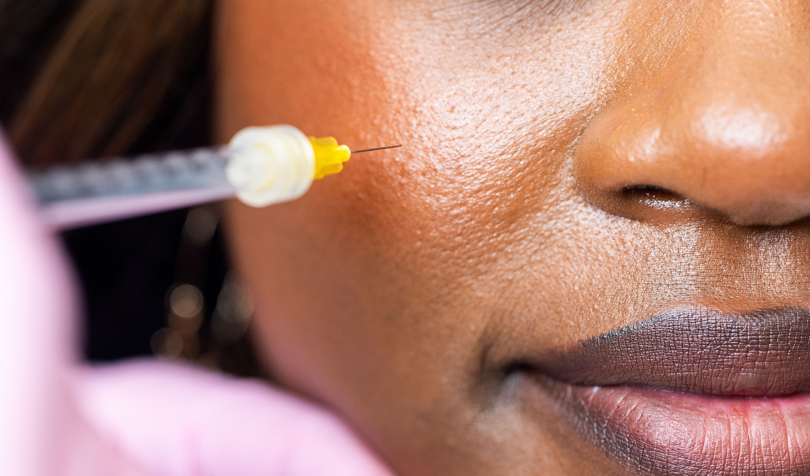 Professional holding syringe in aesthetic clinic.