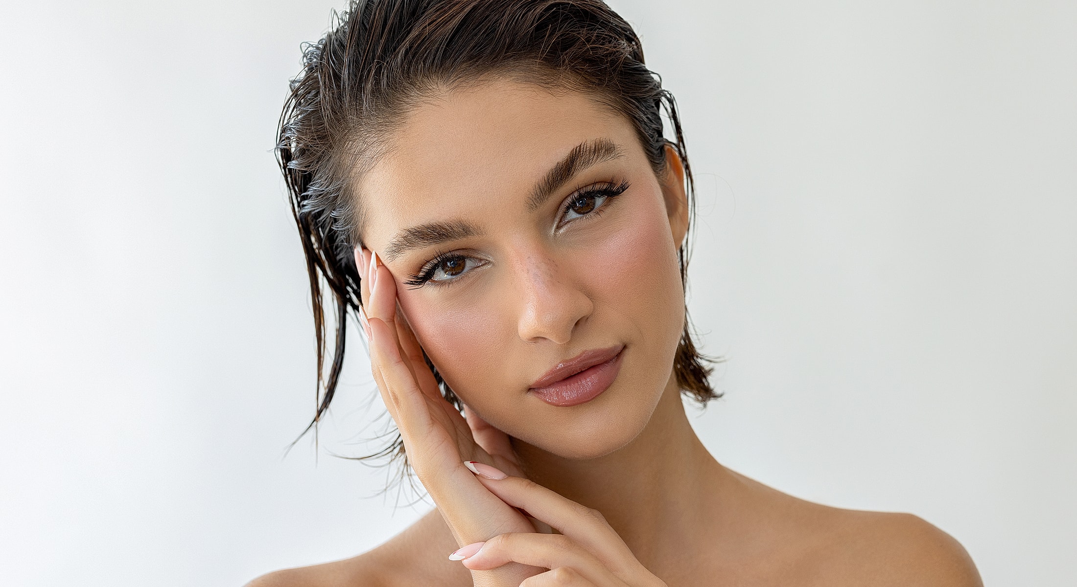 Person with wet hair posing against light background.